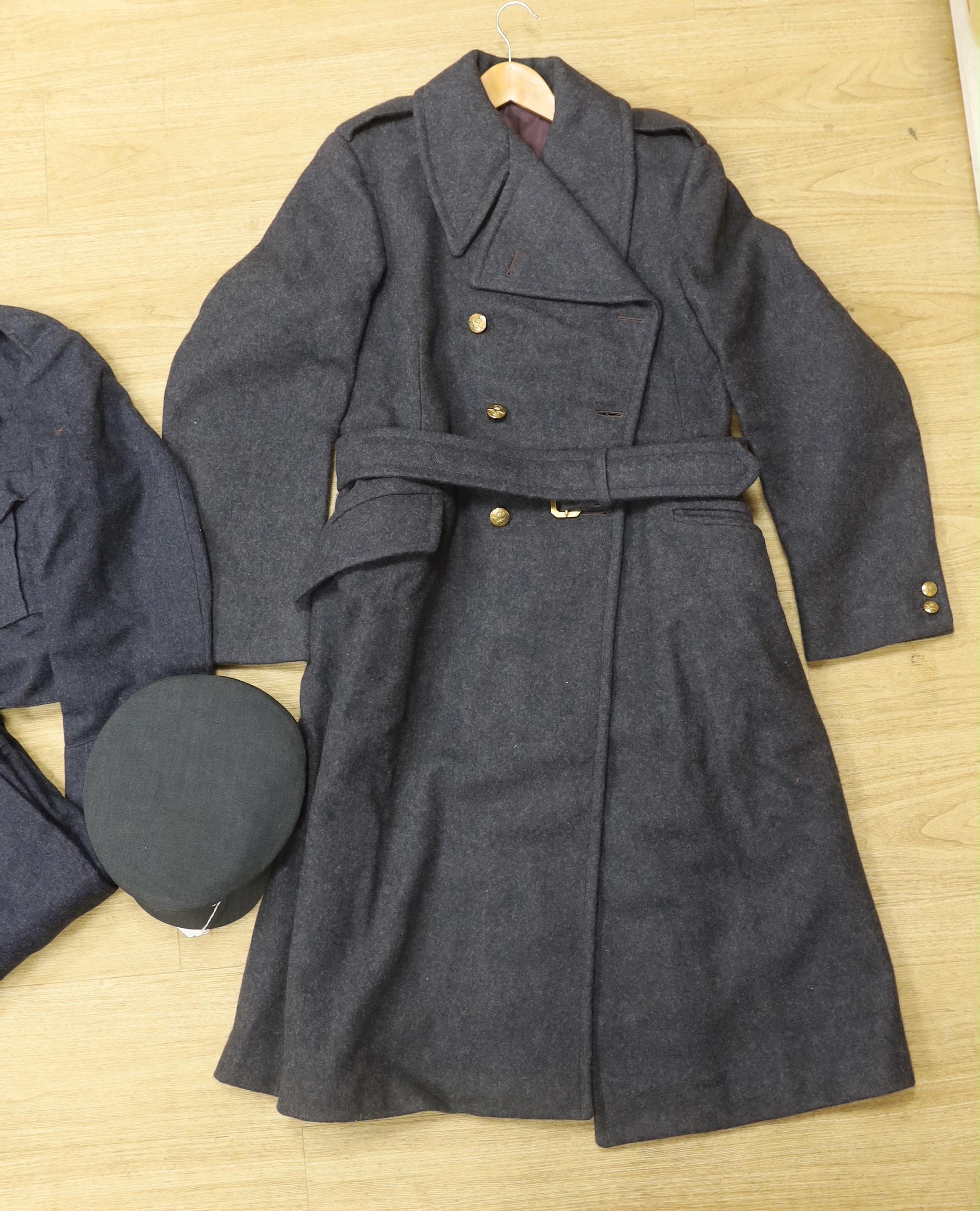 A 1960s RAF uniform comprising; great coat, blouse, cap and trousers, all with manufacturer’s labels, broad arrow markings, dates, etc.